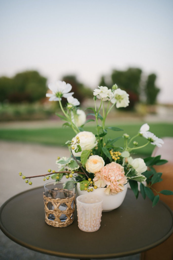 Florals and votives on top of brass metal accent table from Avenue Twelve furniture rentals